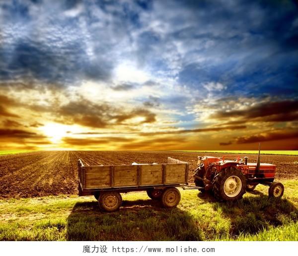 夕阳落日下在农田田埂中的拖拉机播种希望的田野图片